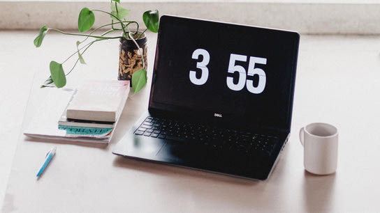 A laptop on showing a full-screen digital clock.