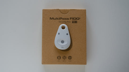A chunky white keychain dongle laying on top of a box labled Feitian MultiPass.